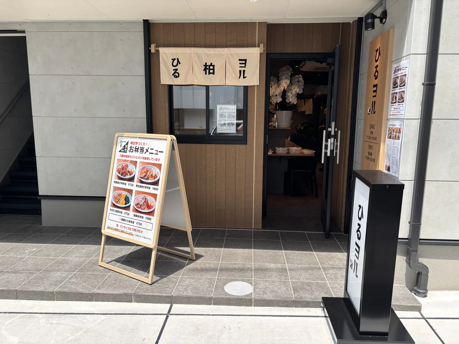 のれんと木目の看板が目印の店舗正面